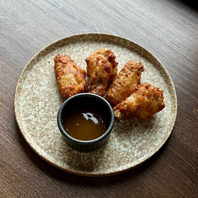 Куриные крылья в панировке с соусом в Sterling гастро паб по цене 600 ₽