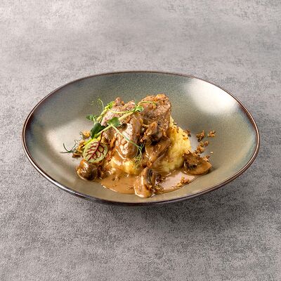 Томленая свинина в сливочно-грибном соусе в Сибирская Корона по цене 699 ₽