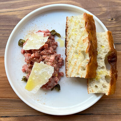 Тартар из говядины с анчоусами и фокаччей в Прошуттерия по цене 1130 ₽