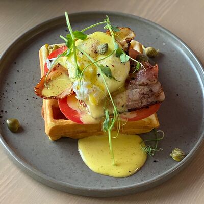 Бельгийская вафля с беконом, томатами и яйцом пашот под голландским соусом в Raison D’être по цене 490 ₽