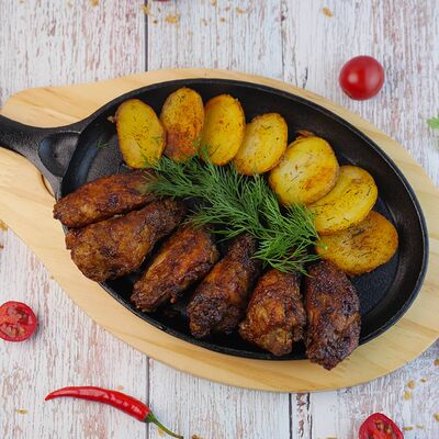 Куриные крылья BBQ с запеченными дольками картофеляв Гастробар Крапива по цене 580 ₽