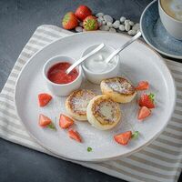 Сырники со сметаной и клубнично-базиликовым соусом в Encore Cafe