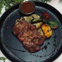 Стейк свиной с овощами и печенным картофелем в Edateca