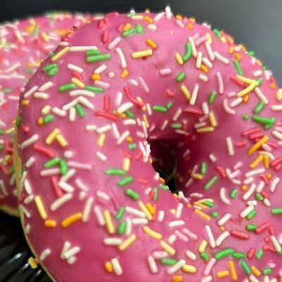 Пончик-донатс с клубничной начинкой и розовой глазурью с цветной посыпкой в Hancoffe по цене 210 ₽