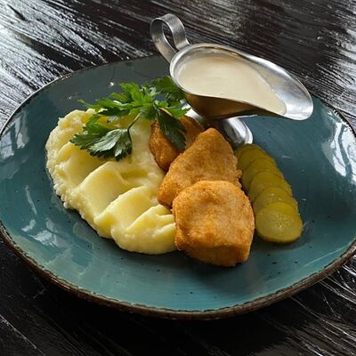 Наггетсы куриные, картофельное пюре, сливочно-сырный соус, соленый огурец в Длинный нос по цене 390 ₽