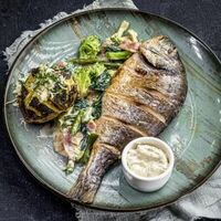 Дорадо с картофелем из огня и овощами с беконом в Бык и море