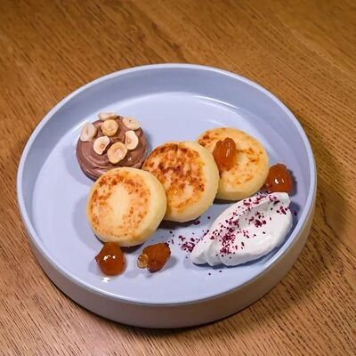 Сырники с копчёным сыром сулугуни и вареньем из белой черешни в PRO.Хинкали by Novikov по цене 500 ₽
