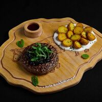 Бифштекс из мраморной телятины с луком конфи и бейби картофелем с брусничным соусом в Level kitchenbar