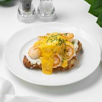 Круассан с креветками, авокадо, яйцом пашот и соусом голландез в Eclair