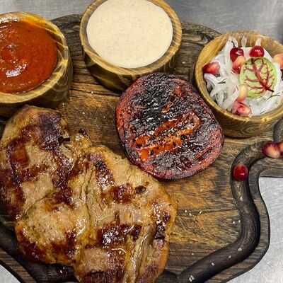 Стейк из свиной шеи с обожженным томатом, маринованным луком и двумя соусами в To mesto по цене 850 ₽