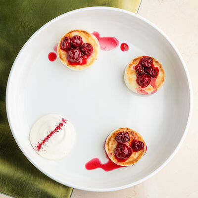 Сырники со сметаной и вишней в Муссоны по цене 520 ₽