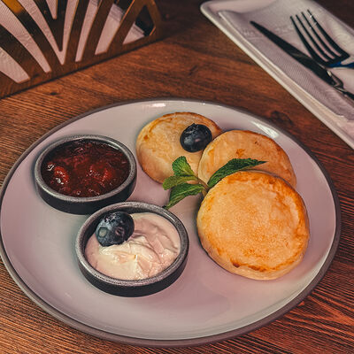 Сырники с ягодным конфитюром и кремом чиз в Масленица по цене 390 ₽