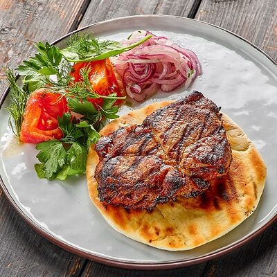 Стейк из свиной шей с теплой лепешкой , солеными томатами и маринованным луком в Про печь по цене 865 ₽