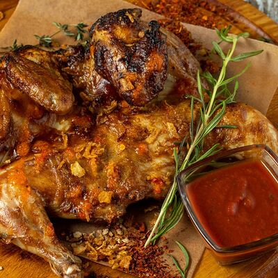 Цыпленок табака, запеченный с чесноком и острым соусом в William Bass по цене 950 ₽