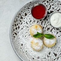 Сырники из рикотты с клубничным муссом и сметаной в Hygge Kafe