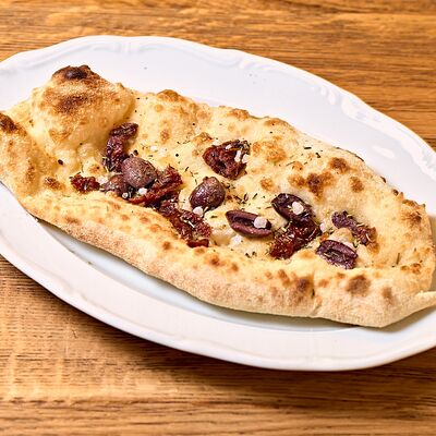 Лепешка с вялеными томатами и оливкамив Кафе Итальянцы по цене 190 ₽