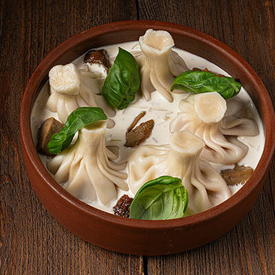 Хинкали с курицей и копченым сулугуни в грибном соусе в Курагадиван по цене 390