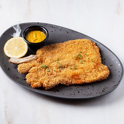 Шницель из свиной корейки на кости с горчичным соусом и лимоном в Brasserie Lambic по цене 990 ₽