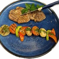 Стейк cвинoй с овощами гриль в Olivia