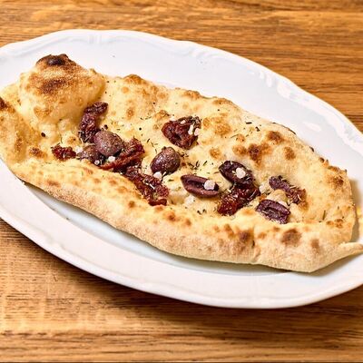 Лепешка с вялеными томатами и оливками в Итальянцы по цене 190 ₽