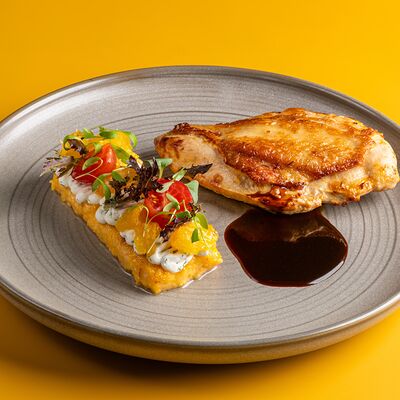 Запеченная куриная грудка, полента, творожный крем, обжаренные томаты, пряный апельсин, чили в Винология по цене 890 ₽