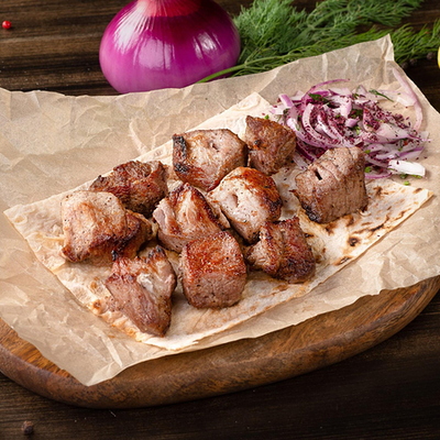 Порция cвинoго шашлыка на тарелке в Сытый волк по цене 470 ₽