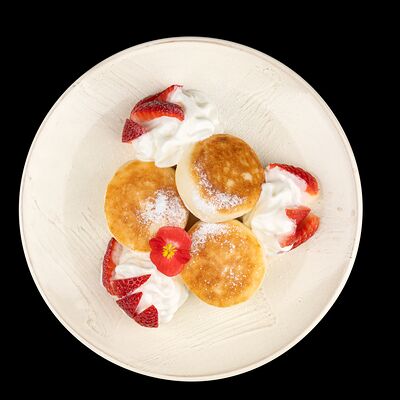 Сырники зернистые со взбитыми сливками и клубникой в Пархаус по цене 590 ₽