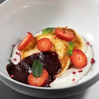 Сырники со сливочным кремом и соусом из черной смородины в Где нас нет