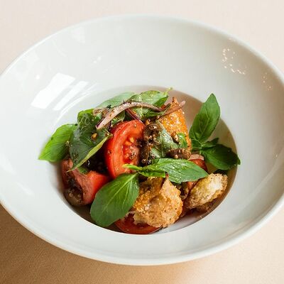 Салат из розовых томатов с таджарскими маслинами и брускеттой в Беллуччи по цене 490