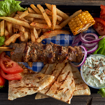 Шашлык cвинoй с картофелем фри на тарелке в Сытый волк по цене 470 ₽