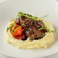 Томленые в портвейне говяжьи щёчки с мятым картофелем и запечёнными томатами в АндерСон