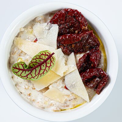 Овсяная каша с вялеными томатами, трюфельным маслом, пармезаном в Delorean по цене 340 ₽