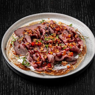 Слоеная лепёшка роти с копченым ростбифом,кремом фета и луком фри в Brasserie Lambic по цене 1160 ₽