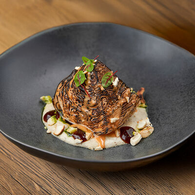 Стейк из капусты с соусом из белого трюфеля и ореховым кимчи, кешью и семенами тыквы в Белок по цене 830 ₽