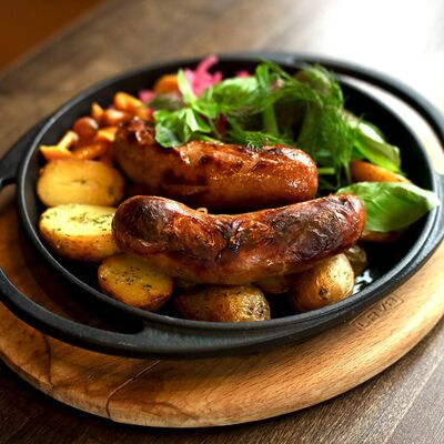 Колбаски в горячей сковородке с картофелем в Sterling гастро паб по цене 1100 ₽