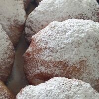 Пончик с шоколадной начинкой посыпан сахарной пудрой в Пончиковая