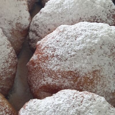 Пончик с шоколадной начинкой посыпан сахарной пудрой в Пончиковая по цене 150 ₽