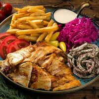 Донер-кебаб из курицы на тарелке с картофелем фри в Istanbul Kebab