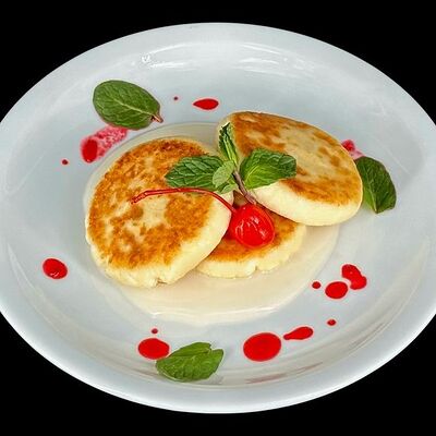 Сырники со сгущённым молоком и вишнёвым джемом в Кейк по цене 249 ₽