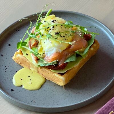 Бельгийская вафля с лососем, соусом песто и яйцом пашот под голландским соусом в Raison D’être по цене 520 ₽