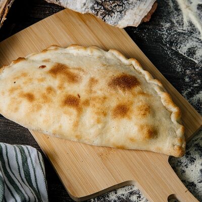 Пицца кальцоне с лососем в Sushi Box по цене 750 ₽