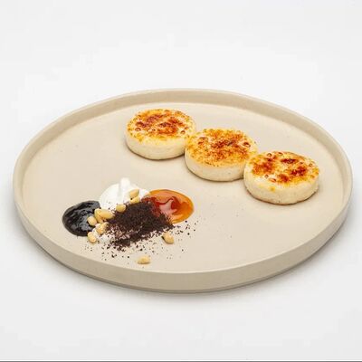 Сырники с творожным кремом, ягодным соусом и миксом из семечек в Le dessert по цене 590 ₽