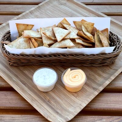 Пшеничные чипсы с сырным и чесночно-йогуртовым соусами в Comida Mexicana по цене 12 р.