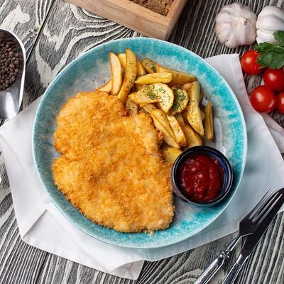 Шницель с томатным соусом и картофелем по-деревенски в Линдфорс по цене 945 ₽