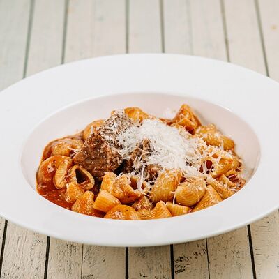 Паста Ригатоне с говядиной в томатном соусе в Перчини на огне по цене 530 ₽