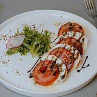 Капрезе из розовых томатов с сыром Моцарелла и соусом Песто в Чикетти