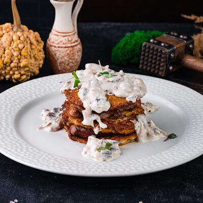 Драники с медальонами из свинины под грибным соусом в ШКВАРКИ по цене 21 р.