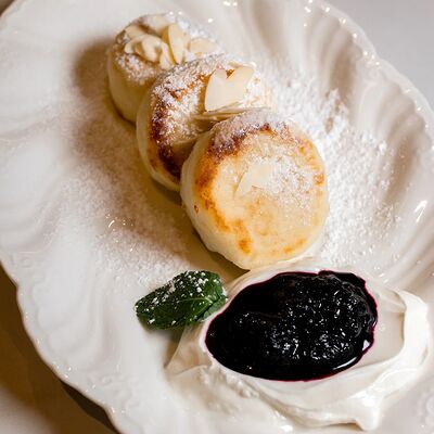 Сырники с тертой черникой и сметанойв Мрамор кофе по цене 465 ₽