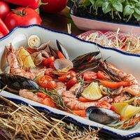 Большое блюдо морепродуктов, приготовленное в угольной печи с томатами черри, травами и белым вином в Belka