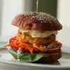 Бургер с котлетой из трески и форели, глазуньей, капустой и морковкой по-корейски, соусами горчичный и BBQ в Зерно по цене 620
